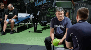 Exercise physiologist assisting a client with an exercise ball during a WorkCover rehabilitation session